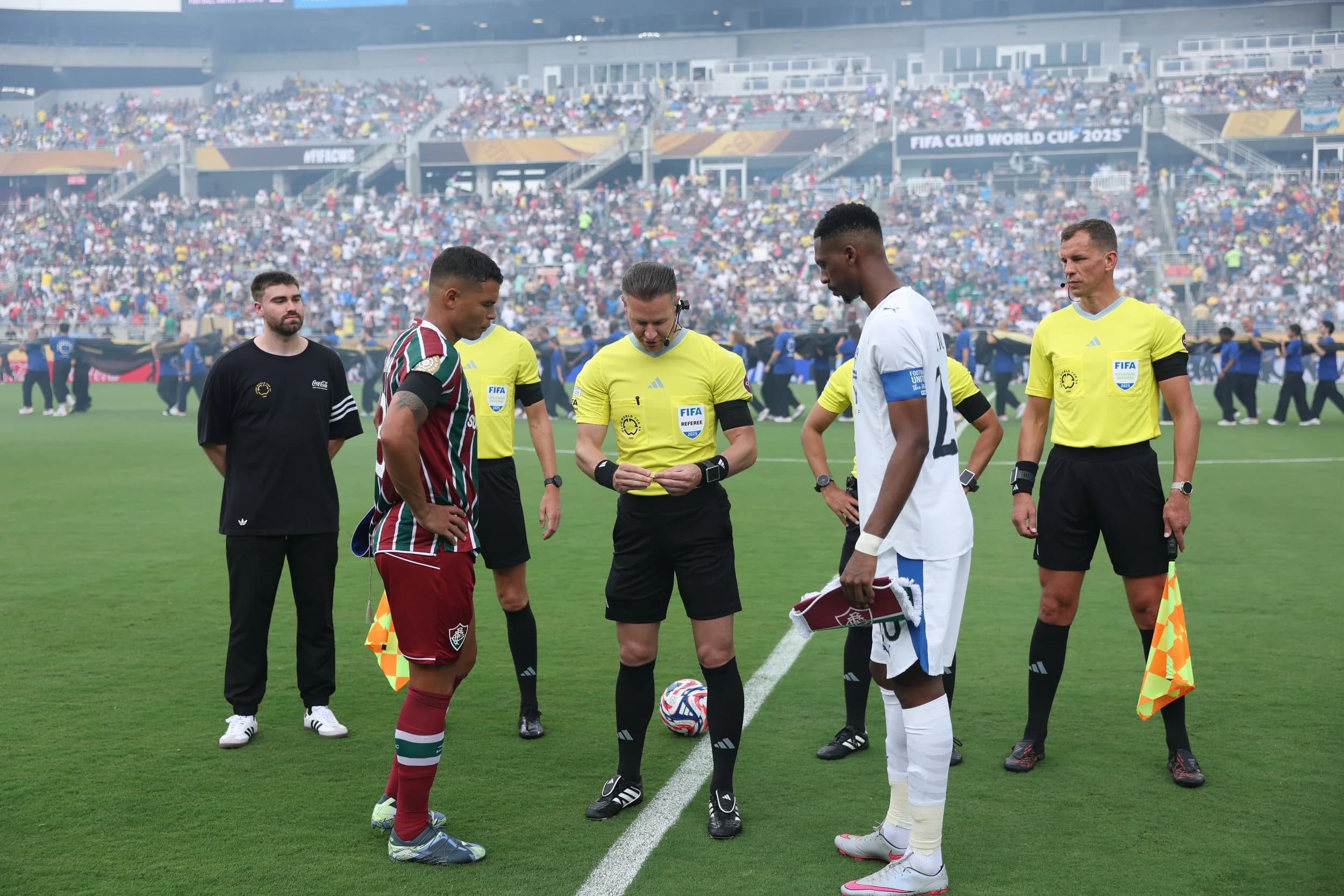 Chummy's Customs next to refs and team captains as Coca-Cola official coin toss assistant
